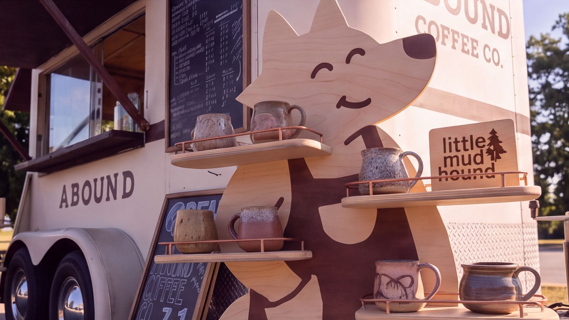 Little Mud Hound’s dog-shaped ceramics shelf beside the Abound coffee trailer